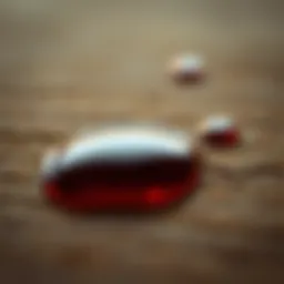 A close-up of essential oil droplets on a wooden surface, showcasing their rich color and viscosity.